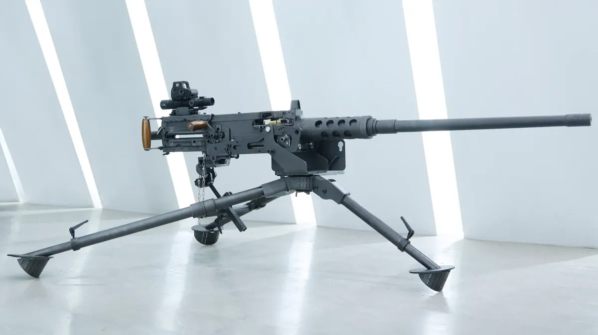 Close-up of a mounted black military machine gun in an indoor setting.